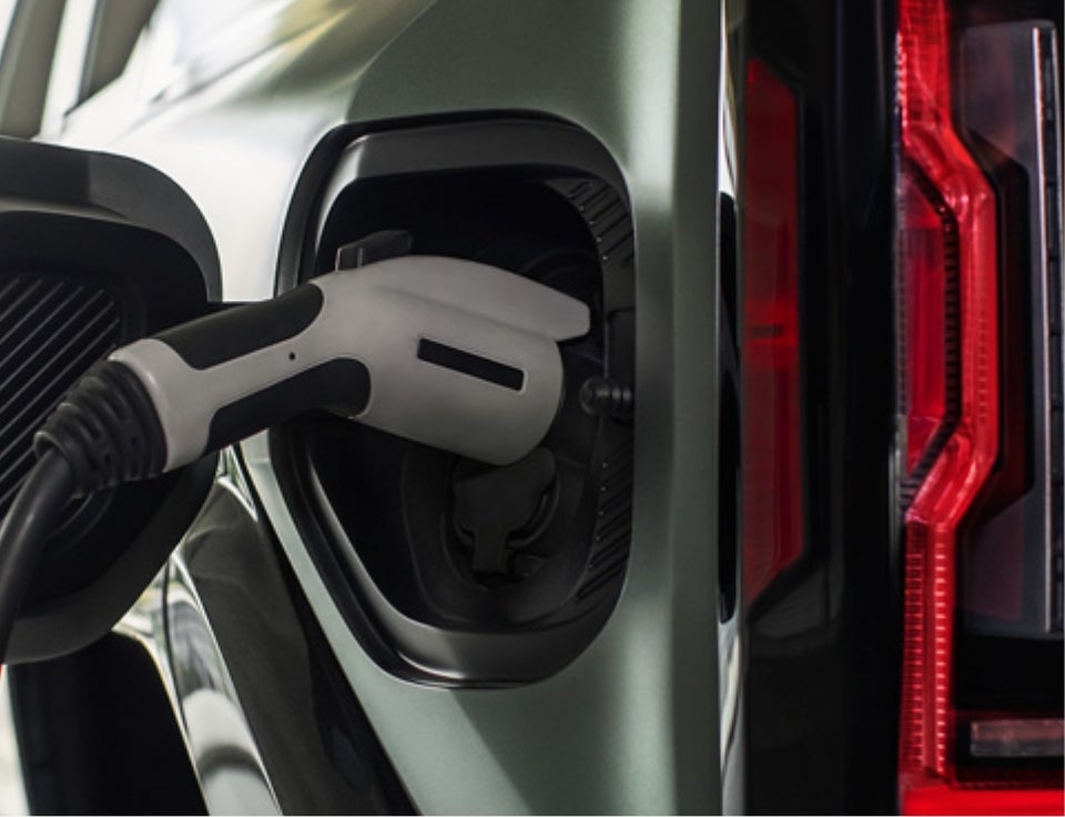 Close up of charging port with charger plugged in on a GMC Hummer EV SUV - McDonald GMC in Saginaw MI